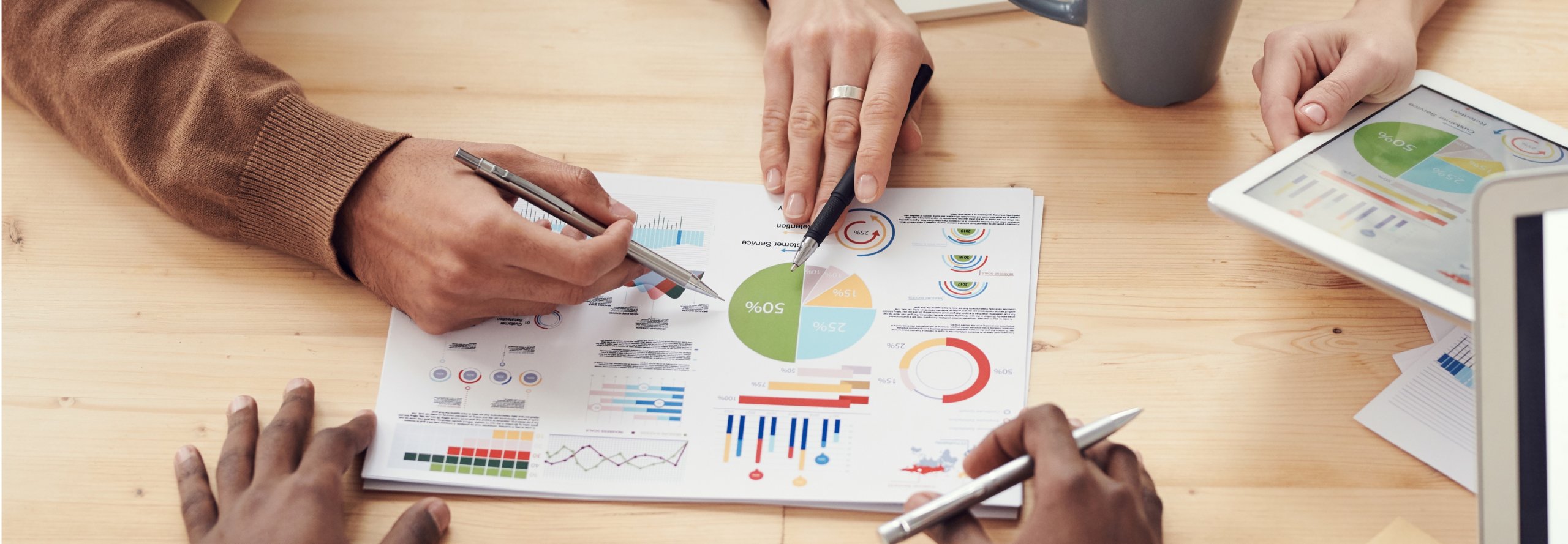 Use Analytics Data to Help Improve Your Google Quality Score meeting table with google’s quality score keyword measurement data report on it