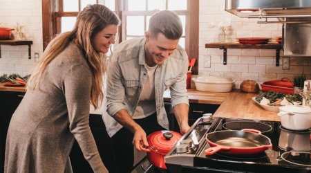 young couple using kitchen appliances