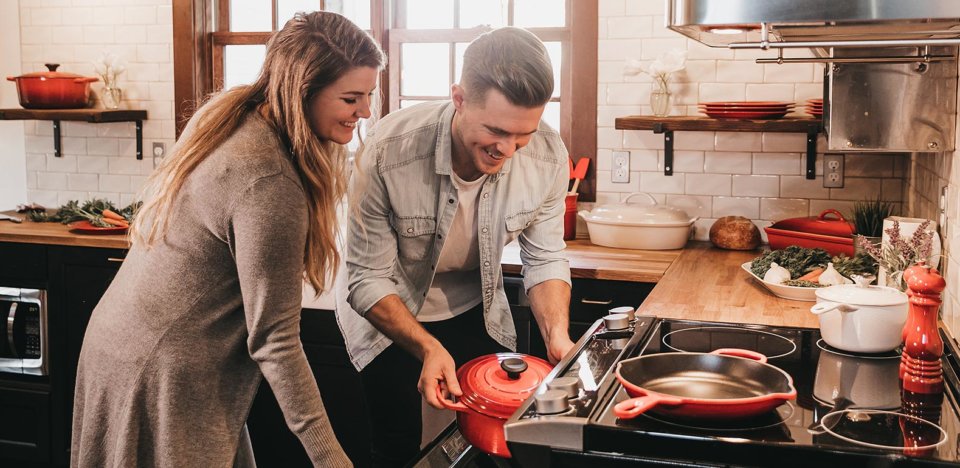 young couple using kitchen appliances