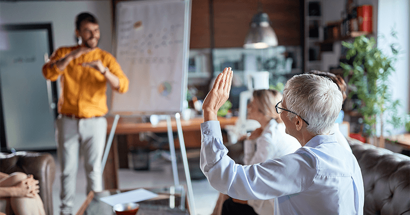 woman raising hand to ask a question during a presentation