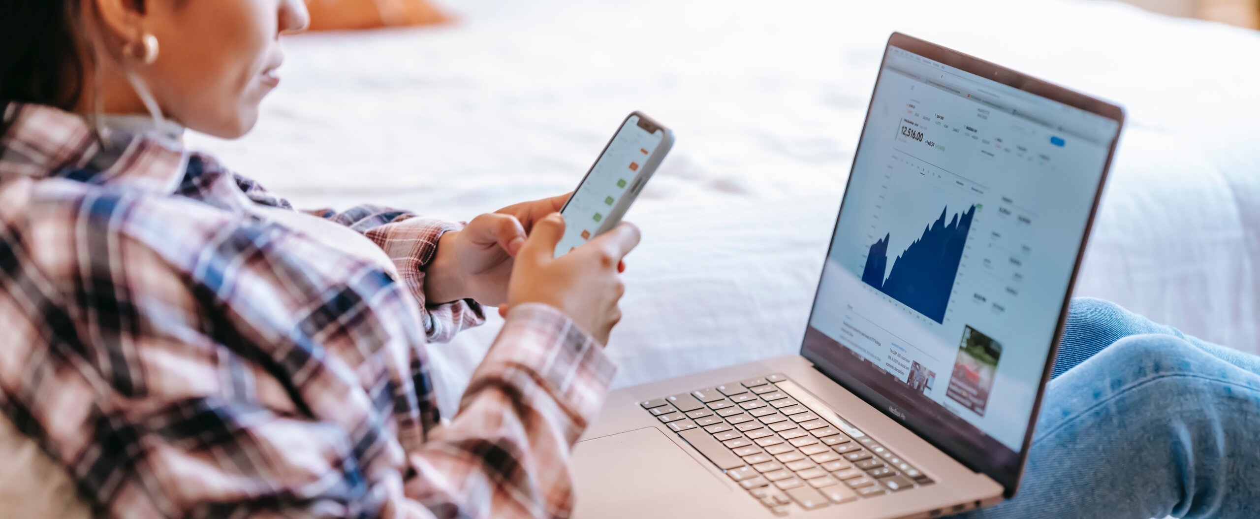 woman on laptop and phone preparing data for data warehouse