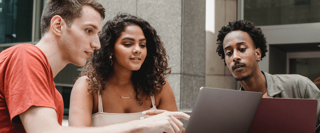 three young colleagues work together on a laptop