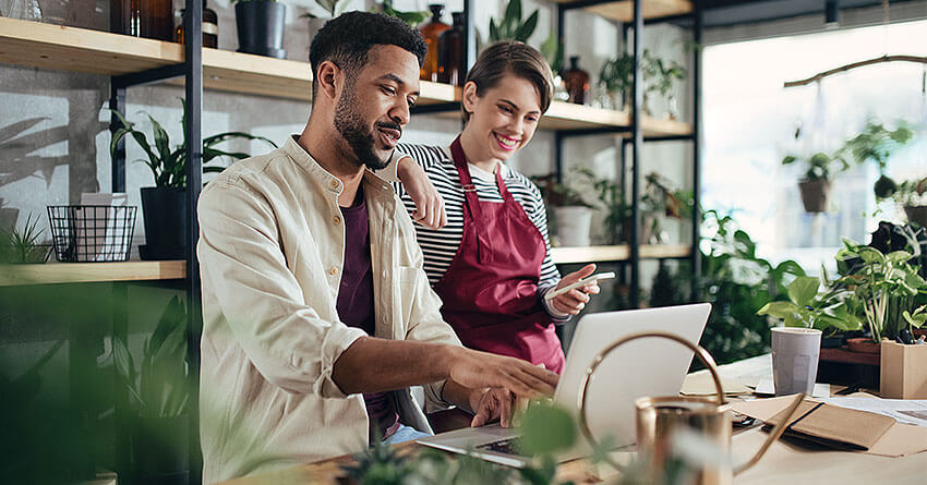 business owners looking at customer journey analytics on laptop