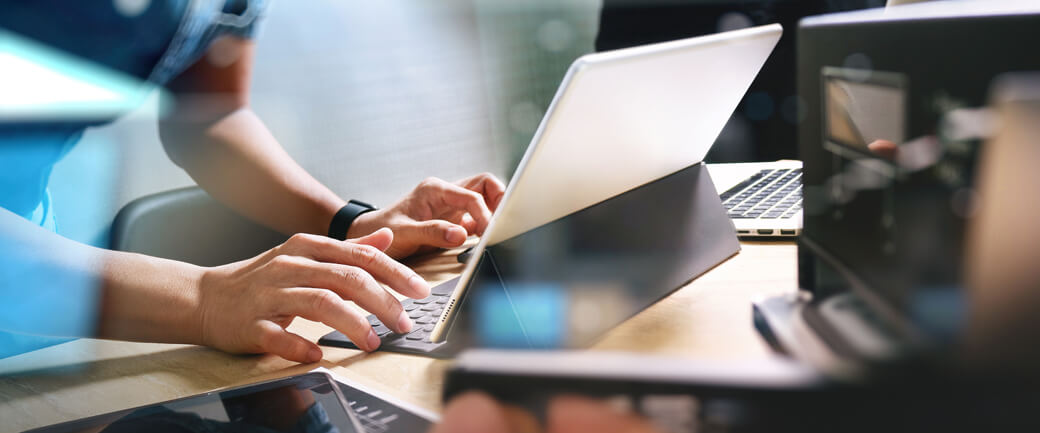 A person types on a tablet device