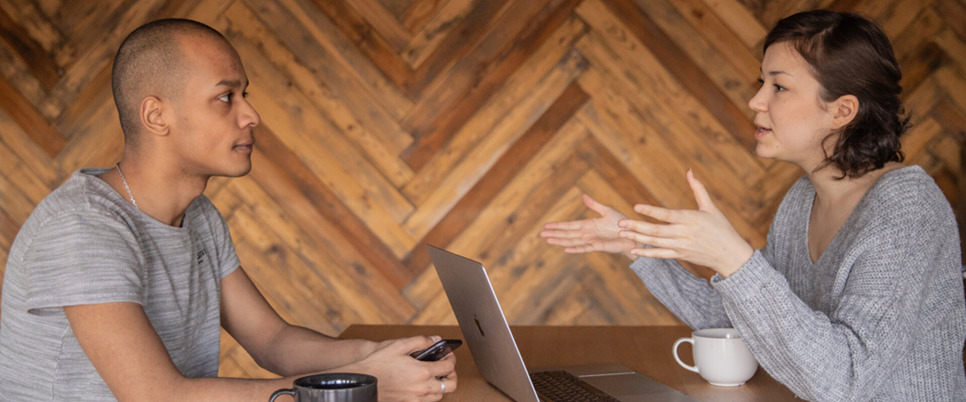 Two people have a discussion at a table
