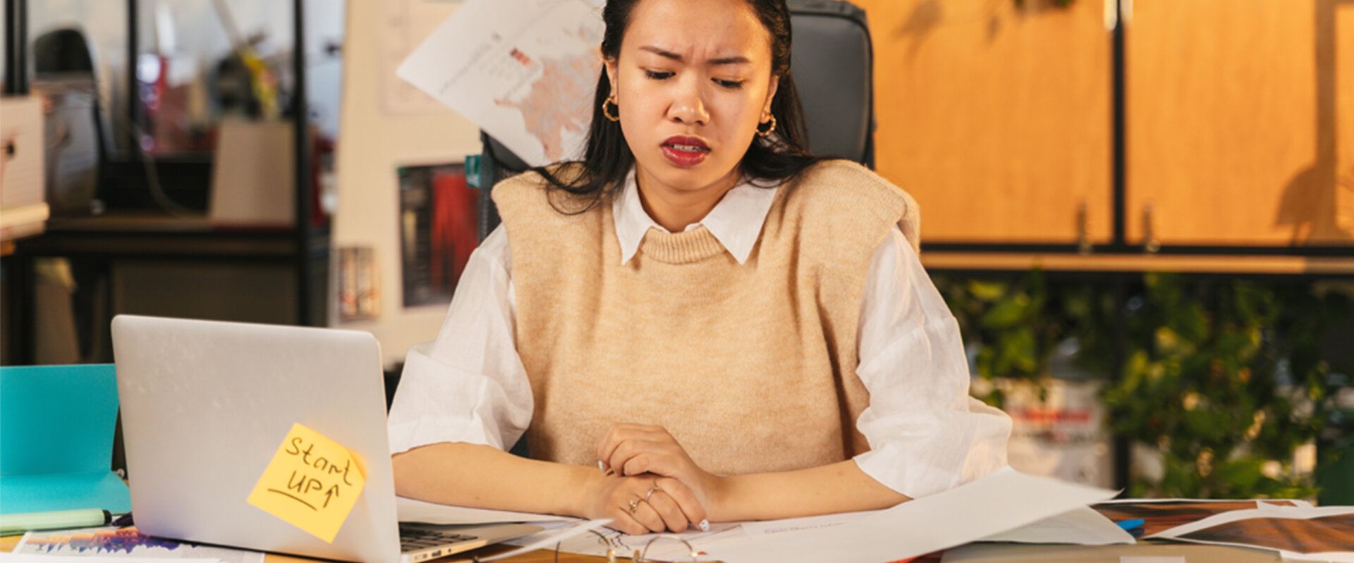 An exasperated woman at a cluttered desk