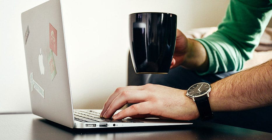 man working on laptop with coffee